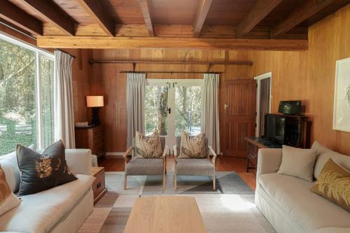 a living room with two couches and a table at Rockwood Karkloof Forest Lodge & Mountain Cabin in Karkloof Nature Reserve