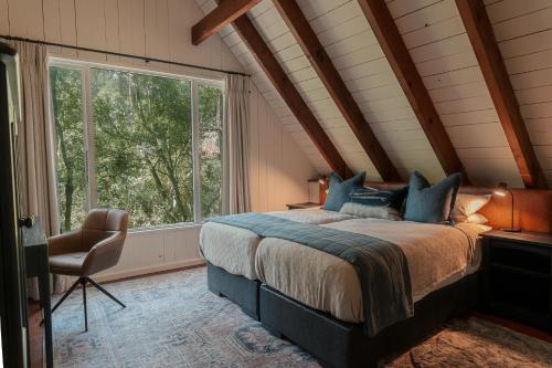 a bedroom with a large bed and a window at Rockwood Karkloof Forest Lodge & Mountain Cabin in Karkloof Nature Reserve