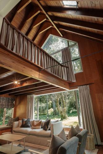 a living room with a staircase in a house at Rockwood Karkloof Forest Lodge & Mountain Cabin in Karkloof Nature Reserve