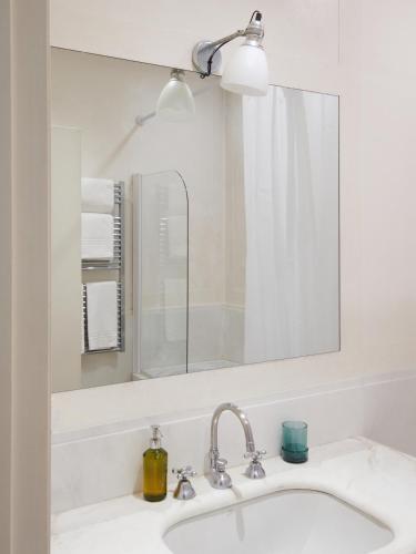 a white bathroom sink with a mirror and a sink at Palazzo Contarini Della Porta Di Ferro in Venice