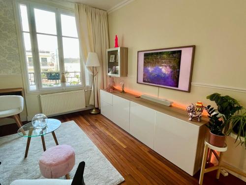a living room with a flat screen tv on a wall at Cerise's home - Cosy flat 15min from Paris with hot tub in Levallois-Perret