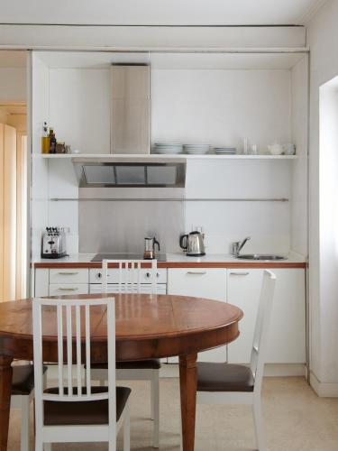 a kitchen with a wooden table and white chairs at Palazzo Contarini Della Porta Di Ferro in Venice