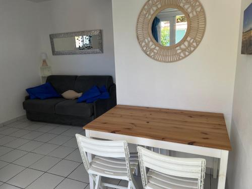 - un salon avec une table, des chaises et un miroir dans l'établissement APPART BISCA plage, à Biscarrosse