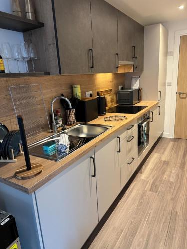 a kitchen with a sink and a counter top at Hightide luxury seaside apartment in Exmouth