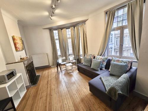 a living room with a couch and some windows at Résidence Marianne 2 in Brussels