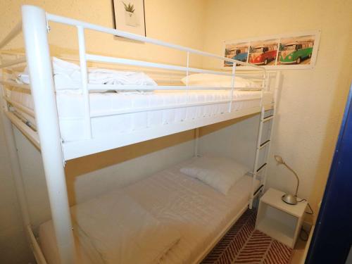 - une chambre avec 2 lits superposés et des rails blancs dans l'établissement Studio Cabine Centre-Ville, Parking & Animaux Acceptés - FR-1-307-274, à La Grande Motte