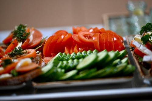 a plate of food with tomatoes and asparagus at Das ACKER Hotel in Neuburg an der Donau