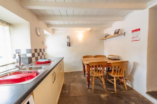 a kitchen with a table and chairs and a sink at The Bolthole, Leyburn in Leyburn