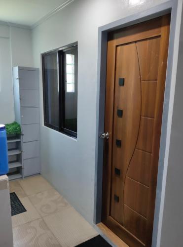 a hallway with a wooden door and a window at Eddie's Value Room for Practical Group Stay in downtown San Fernando in San Fernando