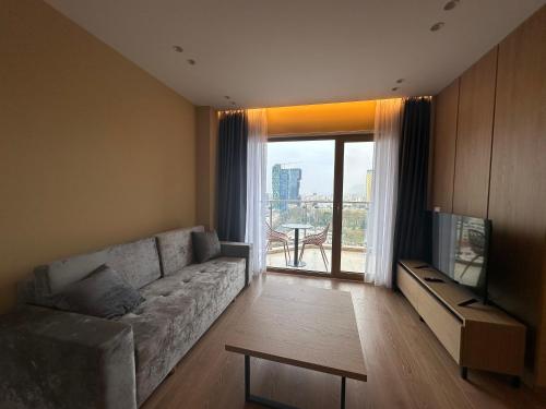 a living room with a couch and a television at Mulaj Hotel in Tirana