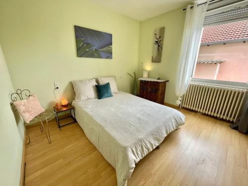 a bedroom with a bed and a chair and a window at 1er etage entier, 2 Appartements, 10 Pers in Delle