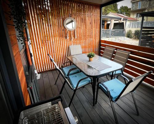 a table and chairs on a deck with a mirror at Mobile homes Marea in Turanj