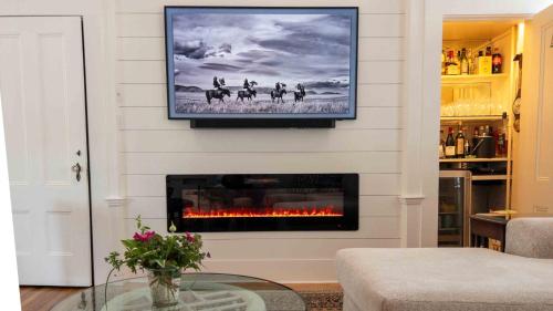 a living room with a fireplace and a tv on the wall at Captain Morse House - Luxury, Waterfront, Town, & Beaches - 5 stars in Edgartown