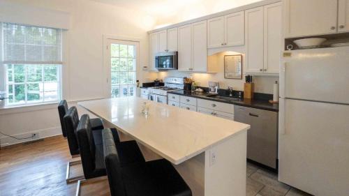 a kitchen with a large table and a refrigerator at Captain Morse House - Luxury, Waterfront, Town, & Beaches - 5 stars in Edgartown