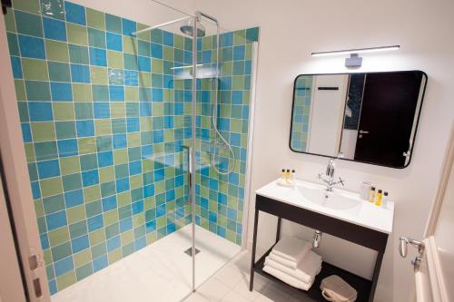 a bathroom with a shower and a sink and a mirror at Villa Aitama in Cap-Ferret