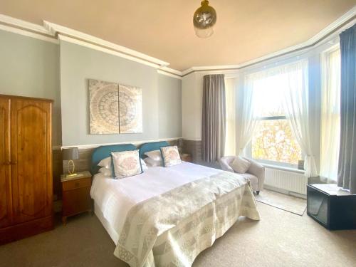 a bedroom with a large bed and a window at Buckingham Lodge Guest House in Torquay