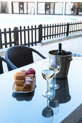 a table with a plate of pastries and glasses of wine at Porto Karras Private Rental, Nilie Hospitality MGMT in Neos Marmaras
