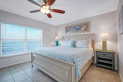 ニュー・スマーナ・ビーチにあるDirect Oceanfront Condo, No-Drive Beach, Great Beach View From Private Balconyのベッドと天井扇風機のある寝室