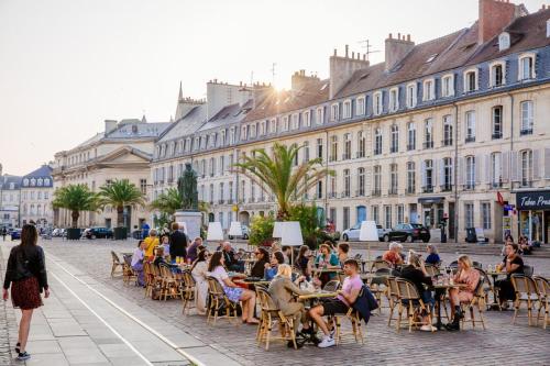 a group of people sitting at tables on a city street at F3 Central, Bright and Quiet in Caen in Caen