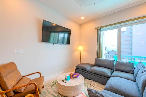 a living room with a couch and a tv at Palm Paradise in South Padre Island