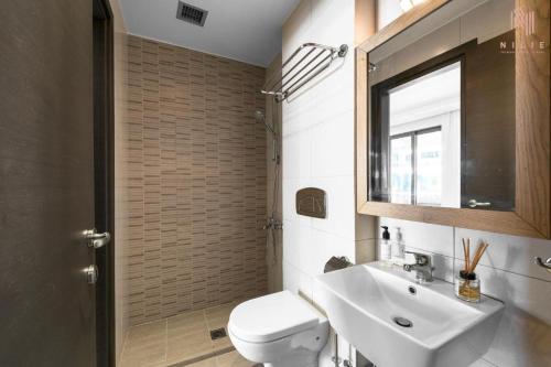 a bathroom with a sink and a toilet and a mirror at Porto Karras Private Rental, Nilie Hospitality MGMT in Neos Marmaras
