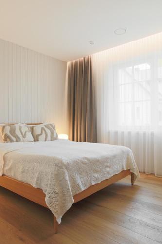 a bedroom with a bed and a large window at Vila 44 in Druskininkai