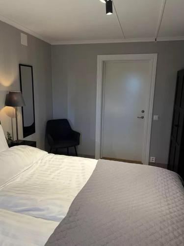 a bedroom with a bed and a door with a chair at Bollnäs bed and breakfast in Bollnäs