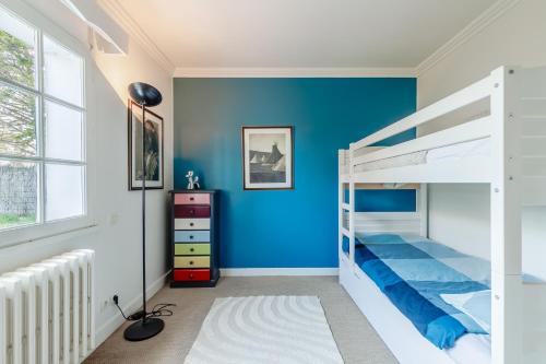 Un dormitorio con paredes azules y una litera. en La Casa du Hameau - A 10min de la Plage, en Saint Gilles Croix de vie