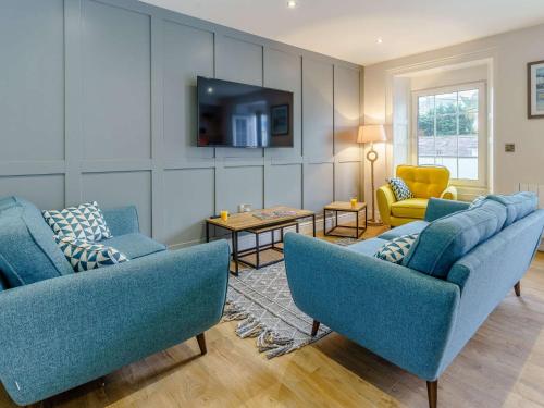 a living room with two blue chairs and a tv at 3 Bed in New Quay 83998 in New Quay
