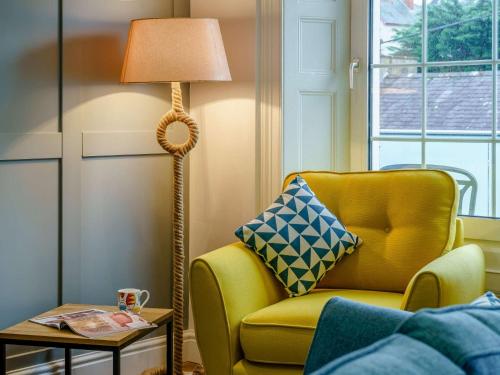 a living room with a yellow chair and a floor lamp at 3 Bed in New Quay 83998 in New Quay