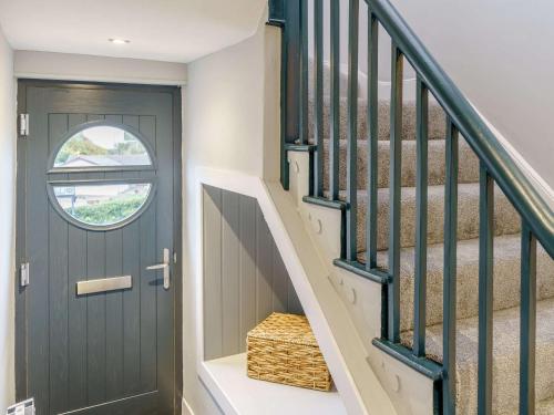 a hallway with a green door and stairs at 3 Bed in New Quay 83998 in New Quay