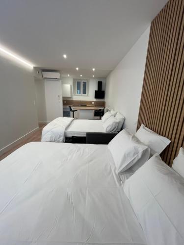 a hotel room with two beds and a kitchen at Studio Hôtel-Restaurant LTB La Table Basque in Biarritz