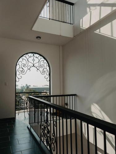 a hallway with an arched door and a balcony at LA MER Homestay Quynhon in Quy Nhon