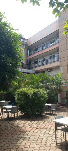 Un edificio con mesas y sillas en un patio. en Super Paradise Hotel, en Kampala