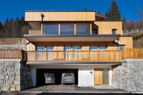 a house with a car parked in a garage at Exklusives Chalet-Haus mit Gletscherblick in Neukirchen am Großvenediger