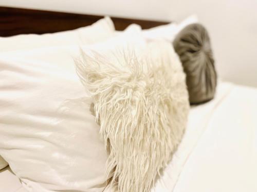 a white pillow with a feather on a bed at KS Unique Studio Apartment in Accra