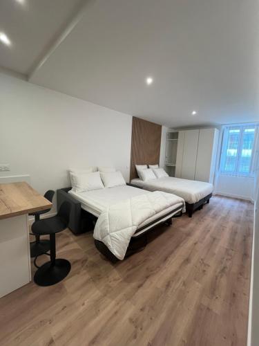 two beds in a room with wooden floors at Studio Hôtel-Restaurant LTB La Table Basque in Biarritz