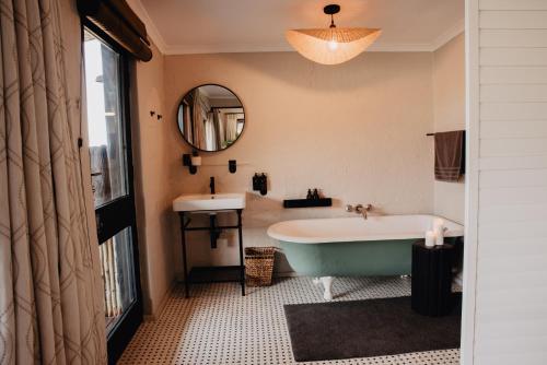 a bathroom with a bath tub and a sink at Rockwood Karkloof Forest Lodge & Mountain Cabin in Karkloof Nature Reserve