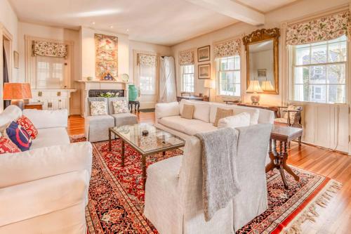 a living room with white furniture and a fireplace at Captain Morse House - Luxury, Waterfront, Town, & Beaches - 5 stars in Edgartown