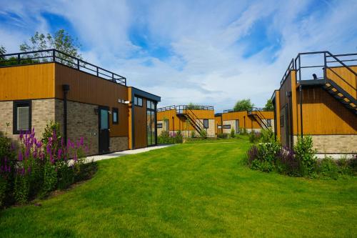 a row of yellow buildings with a green yard at EuroParcs Kagerplassen in Warmond