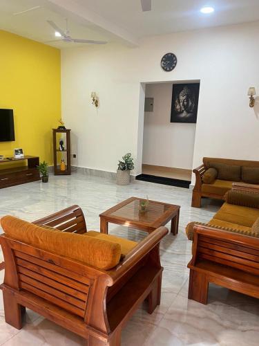 a living room with couches and a coffee table at Wilson's Guest House in Nilwella