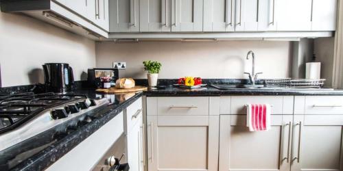 a kitchen with a sink and a stove at Super Chic 1-Bedroom Urban Hideaway in Twickenham