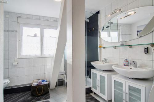 Un baño con dos lavabos y un espejo. en Ferienwohnung Strobel, en Meersburg