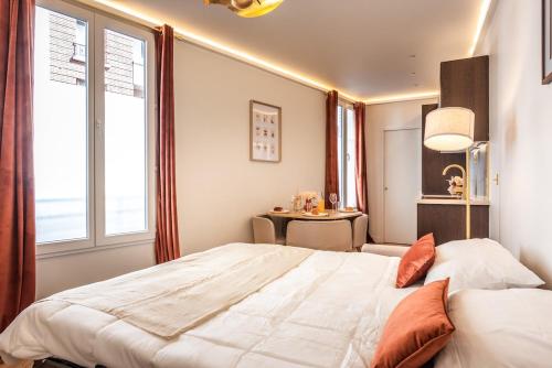 une chambre avec un grand lit et une table dans l'établissement Appartement d'exception avec Jacuzzi et AC - 6P, à Paris