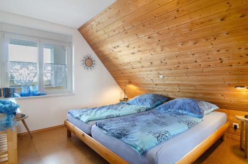 2 camas en un dormitorio con pared de madera en Ferienwohnung Strobel, en Meersburg