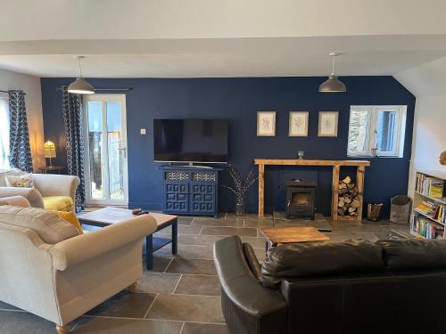 ein Wohnzimmer mit Couch und Kamin in der Unterkunft Bramble Cottage on the edge of Exmoor in Combe Martin