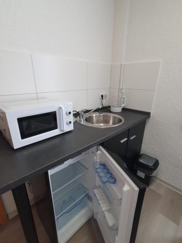 a microwave sitting on a counter next to a sink at Pension Valentina in Mühlau
