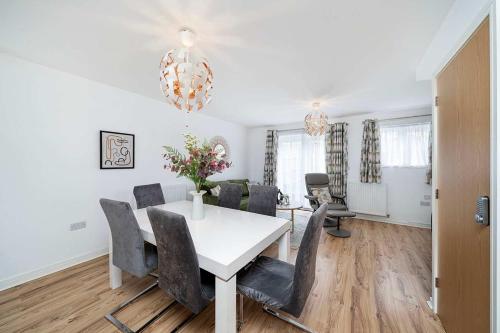 a dining room with a white table and chairs at Chic House With Parking And Private Garden in Northfleet