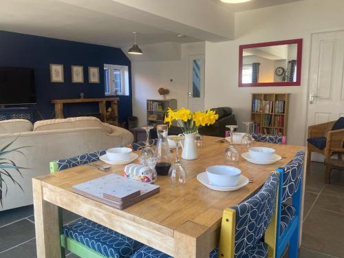 einen Esstisch mit Stühlen und ein Sofa in der Unterkunft Bramble Cottage on the edge of Exmoor in Combe Martin