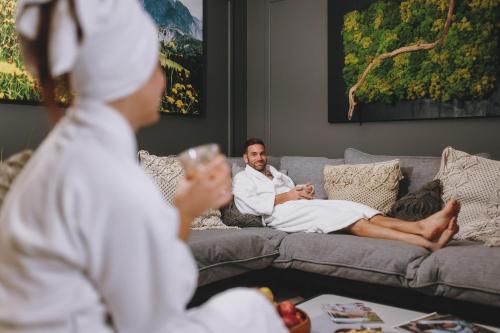 a man laying on a couch with his feet on a table at Superior Sport und Familienresort Alpenblick in Zell am See